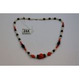 Necklace of freshwater baroque pearls with onyx and coral beads on silver clasp