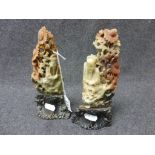 A pair of carved Oriental hardstone figurines depicting elders seated in floral tree, raised on