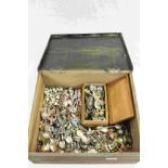 A large quantity of collectors spoons in a wooden box.