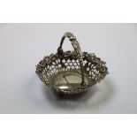 Victorian silver swing handled pierced bowl raised on three bun feet, repousse floral and scroll