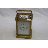 Brass chiming carriage clock, white enamel dial with black Roman numerals with Arabic numerals to