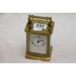Brass carriage clock, white enamel dial with black Roman numerals and black poker hands, makers name