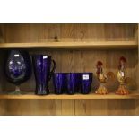 Two Murano style glass Cockerels, a Bristol Blue glass jug & six beakers & a large Goblet with clear