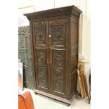 Late 19th century Continental Heavily Carved Oak Wardrobe, the two doors with relief carved panels