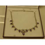 Amethyst silver fringe necklace comprising central quatre-foil amethyst set motif with a further ten