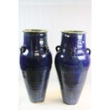Two medium blue glazed Persian wine vessels approximately 76cms high