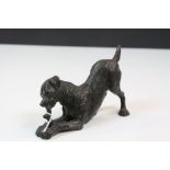 Bronze Dog playing with a Stick in Front Paws