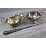 Silver sauce boat raised on three feet with trefoil shaped shoulders, scrolled handle, pie crust