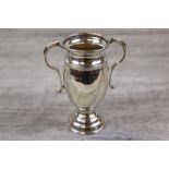 Silver twin handle trophy of urn form, raised on moulded foot, ribbed detailing to rim and neck,