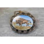 Enamelled silver oval brooch depicting a Buffalo, pierced scroll border surround, makers F C Parry