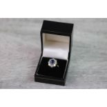 Sapphire and diamond 18ct yellow gold and white gold set cluster ring, the centre oval mixed cut