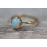 Opal 18ct yellow gold ring, the precious white opal cabochon measuring approximately 7mm x 6mm, four