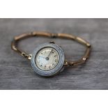 Circa 1920s enamelled yellow metal wristwatch, blue and white guilloche enamelled case, cream