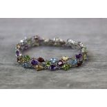 Multi gem set silver bracelet formed of pear shaped mixed cut peridot, citrine, garnet, blue topaz