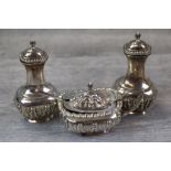 Pair of silver pepperettes, bulbous bases and narrow necks, foliate decoration to lower half,
