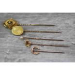 Five Victorian stick pins to include Victorian Etruscan Revival seed pearl enamelled yellow metal