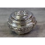 Burmese silver lidded trinket pot, of squat rounded form raised on three scalloped feet, repousse