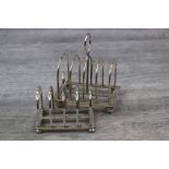 Goldsmiths & Silversmiths silver toast rack of rounded tunnel form raised on four bun feet,