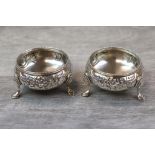 A pair of Victorian open salt cellars raised on three hoof feet, engraved floral decoration with