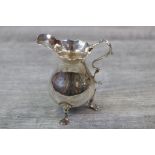 Mid 18th century Georgian silver cream jug of baluster form, raised on three paw feet, scroll handle
