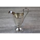 Late Victorian Britannia silver helmet shaped cream jug of plain form raised on square foot,