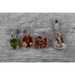 Four gem set pendants to include a red spinel 9ct yellow gold flower shaped pendant, five oval red