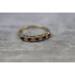 Ruby and diamond 9ct yellow gold dress ring, five small round mixed cut ruby with four alternate