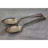 Pair of George III silver spoons with later repousse flower and foliate scroll decoration to