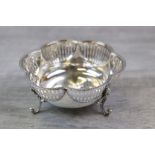 Early George V pierced silver bon bon dish of scalloped form raised on three scrolled ball finial