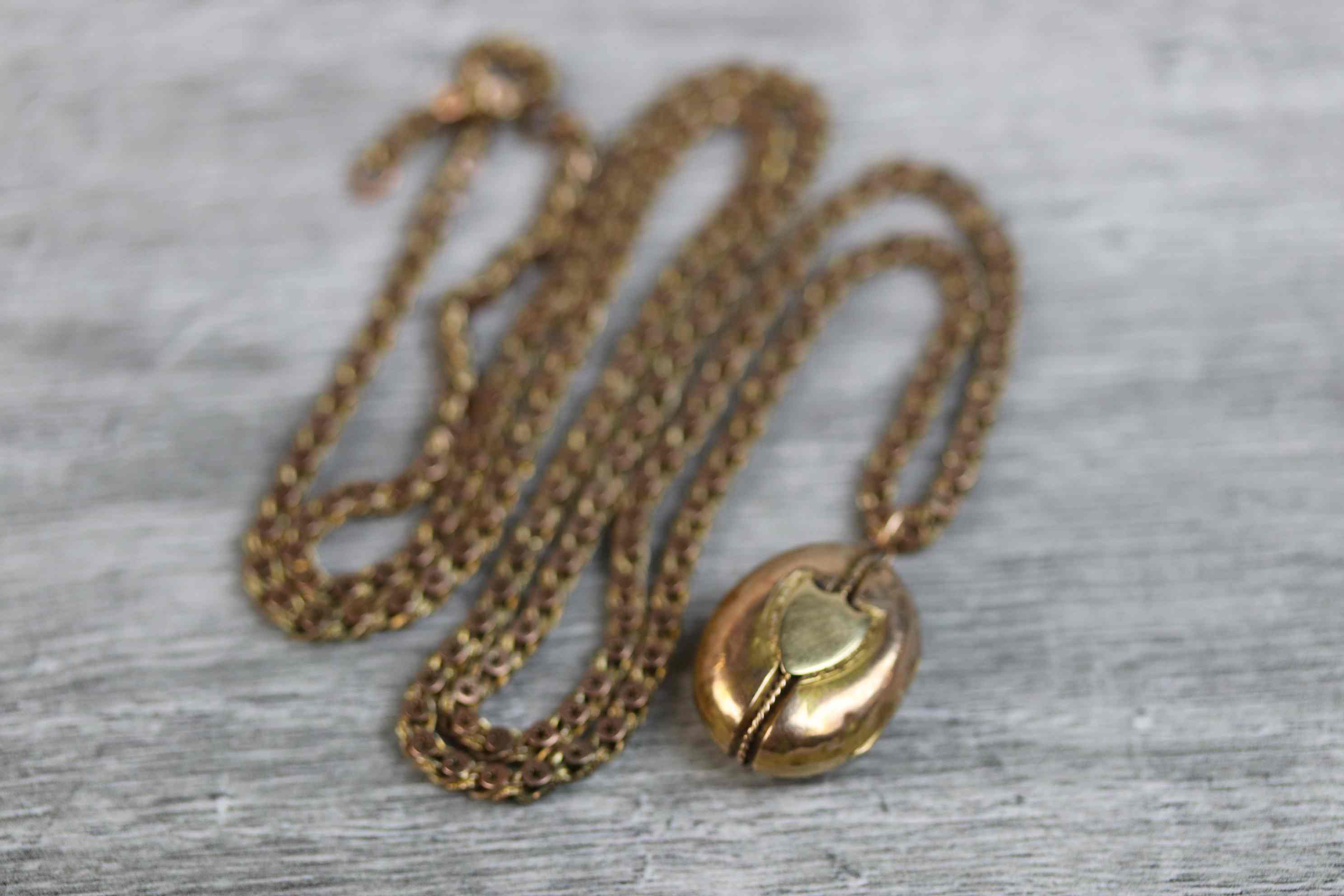 Victorian yellow metal oval locket pendant with blank shield cartouche to centre and rope twist