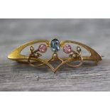 Art Nouveau tourmaline and seed pearl 15ct yellow gold brooch, the sinuous scrolling from set to