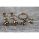 Pair of 9ct yellow gold screw back drop earrings, pierced ball pendant drops suspended on a chair,