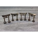 Four Japanese silver novelty pepperette knife rests, modelled as a Japanese arch, the centre