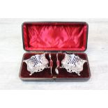 Late Victorian cased set of open silver salt cellars with salt spoons, pierced design raised on four
