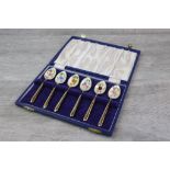Cased set of six enamelled silver gilt coffee spoons, each bowl enamelled with a different floral