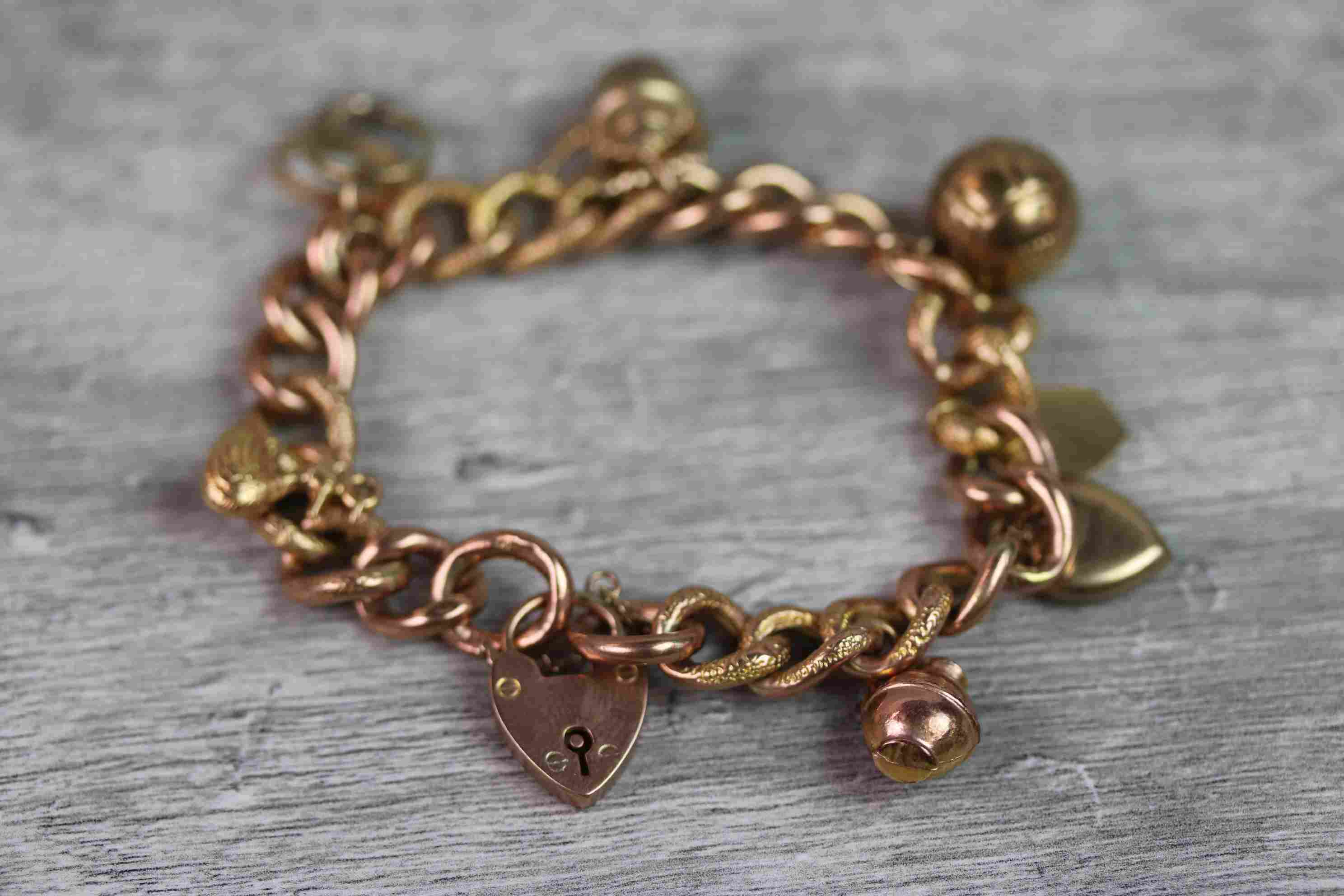 9ct rose gold curb link charm bracelet with 9ct rose gold padlock clasp, seven 9ct gold and yellow - Image 3 of 10