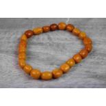 Loose butterscotch amber style beads, circa 1920s/1930s, comprising twenty-three oval beads
