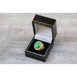 Jade and diamond 18ct yellow gold cluster ring, the centre oval cabochon jade measuring