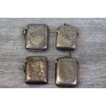 Four silver vesta cases, rectangular form, three with engraved foliate scroll decoration and blank