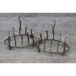 Pair of early George V silver five bar toast racks of oval form raised on four bun feet, makers