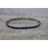 Kyanite 9ct yellow gold line bracelet comprising twenty-eight oval mixed cut kyanite, each kyanite