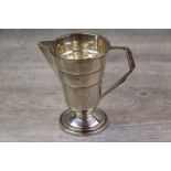 Late Art Deco silver cream jug of rounded stepped form on rounded stepped foot, angular spout and