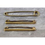 18ct yellow gold tie pin in the form of a safety pin, length approximately 4.5cm together with two