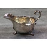 Victorian silver sauce boat raised on three hoof feet with shell design shoulders, scrolled handle