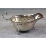 Edwardian Asprey & Co silver sauce boat raised on three feet, scroll handle with acanthus leaf