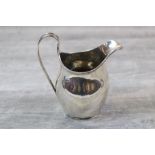 George V silver helmet shaped cream jug of plain form with reeded handle and rim, makers F C