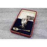 Cased silver egg cup and teaspoon, the egg cup having faceted bowl, makers Adie Brothers Ltd,