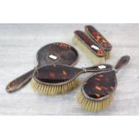 George V five piece tortoiseshell and silver dressing table brush set comprising hand mirror, two
