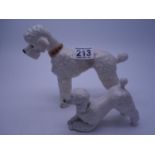 China figurine of a Poodle in a standing position and her pup, in a playful pose