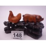 Carved Netsuke style Pig, carved Netsuke style Chicken and a hardwood Japanese stand